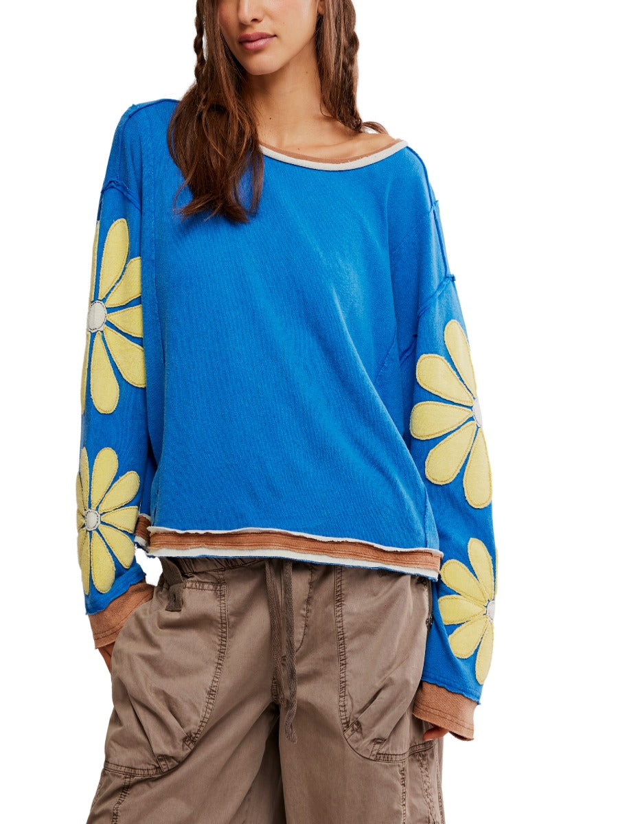 Free People You’re A Star Floral Top in blue with yellow flower sleeves paired with casual brown pants by Free People.