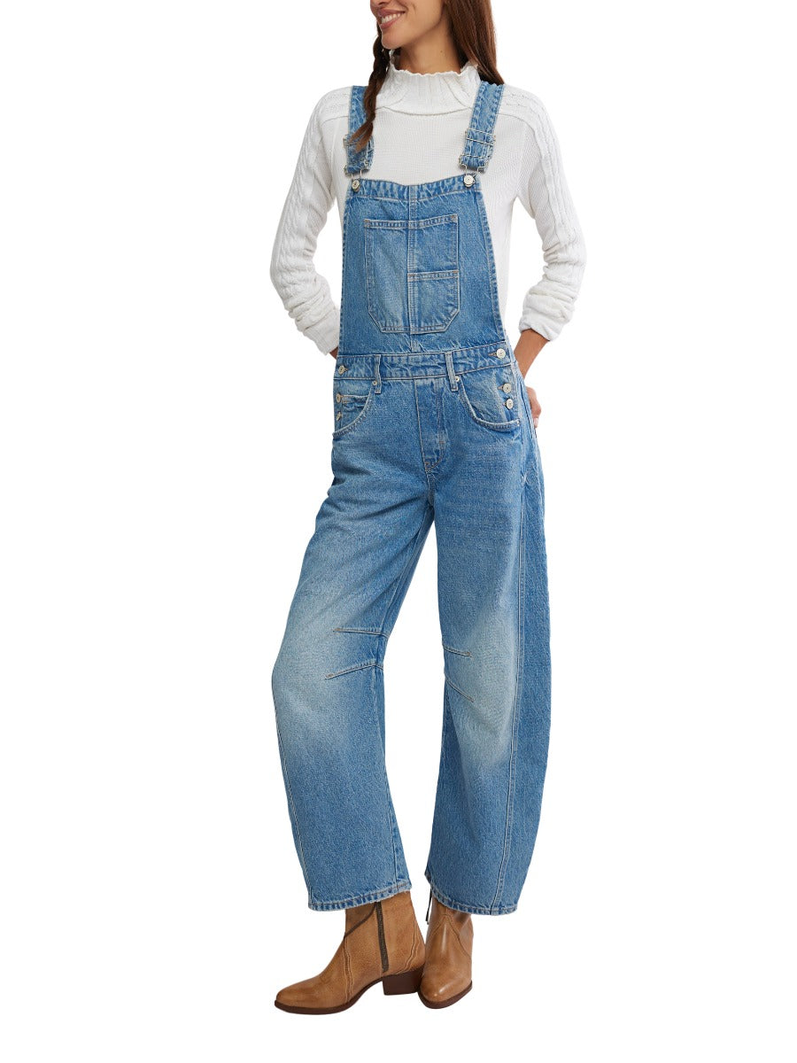 Free People Good Luck Denim Overalls in light blue paired with brown boots and a white sweater by Free People.