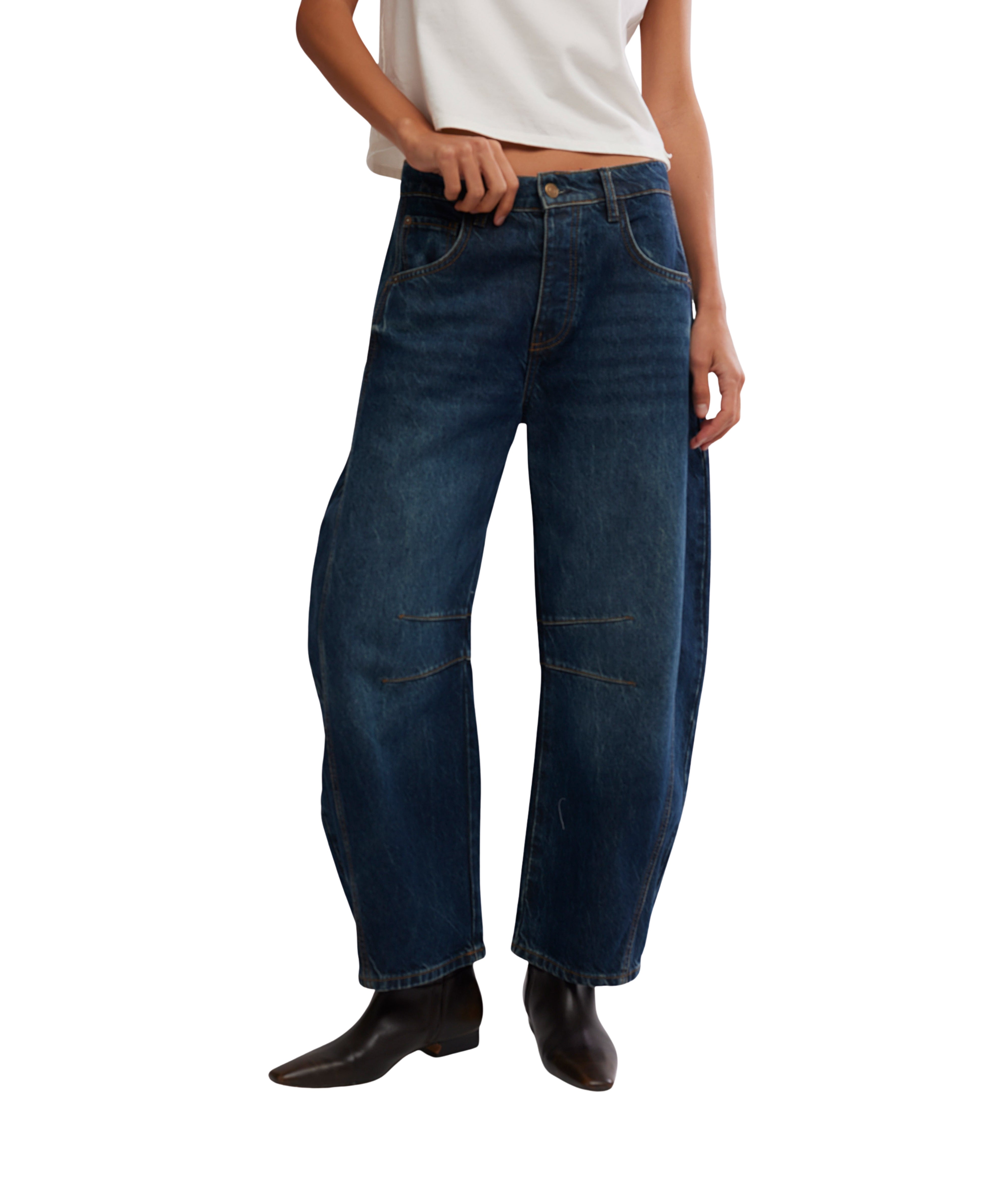 Free People Good Luck Maker Barrel Jeans in dark denim paired with boots and a white top from Free People.