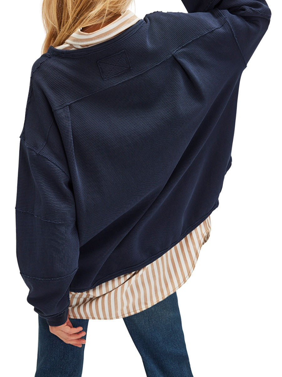 Back view of Free People Total Eclipse Long Sleeve Crew Top in navy, styled with striped shirt and jeans by Free People.