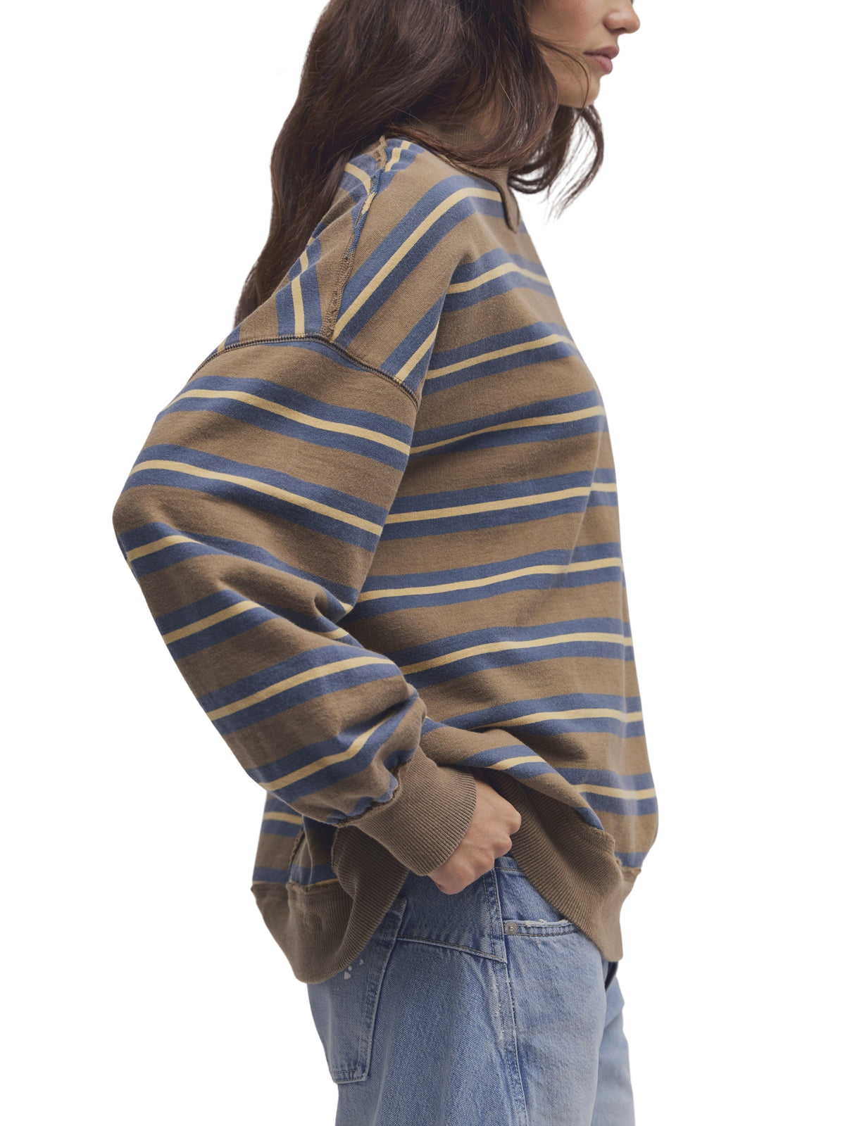 Striped taupe and blue sweater with ribbed cuffs and hem, paired with blue denim jeans
