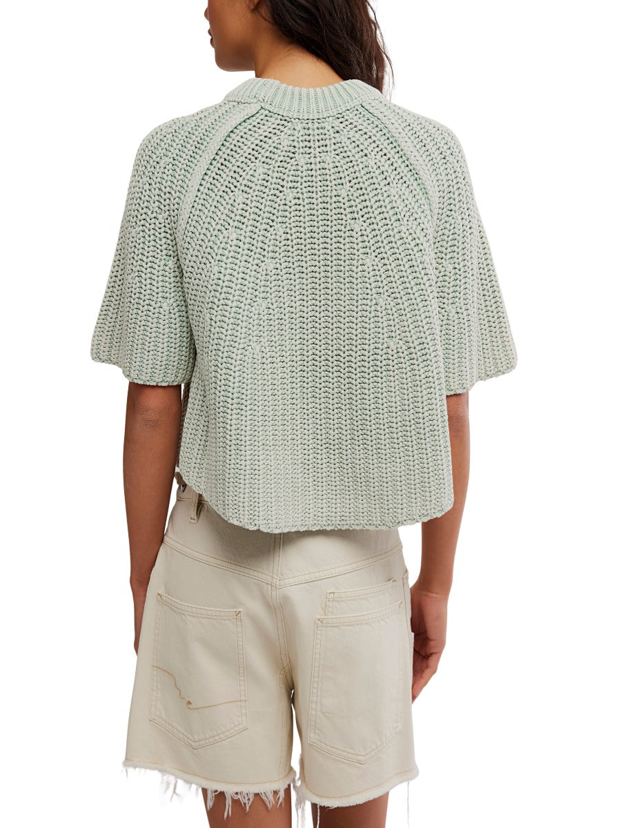 Back view of Free People Amy Washed Half Sleeve Crew Sweater in light green knit worn with beige shorts
