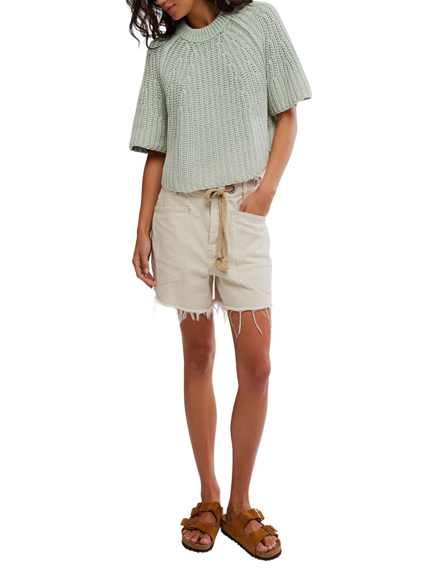 Free People Amy Washed Half Sleeve Crew Sweater in green knit styled with beige shorts and brown sandals by Free People