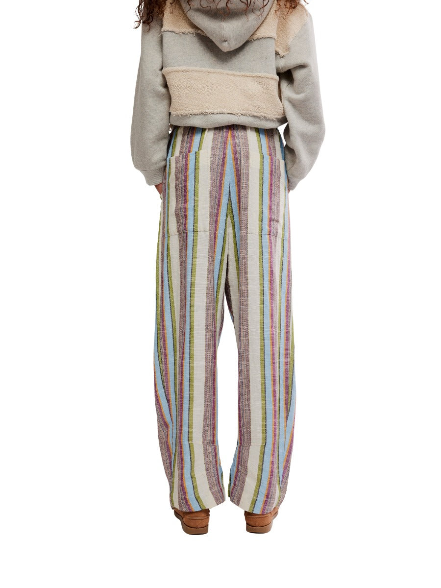 Free People Chambers Laid-Back Stripe Pant with multicolor vertical stripes and relaxed fit, styled with a beige jacket.