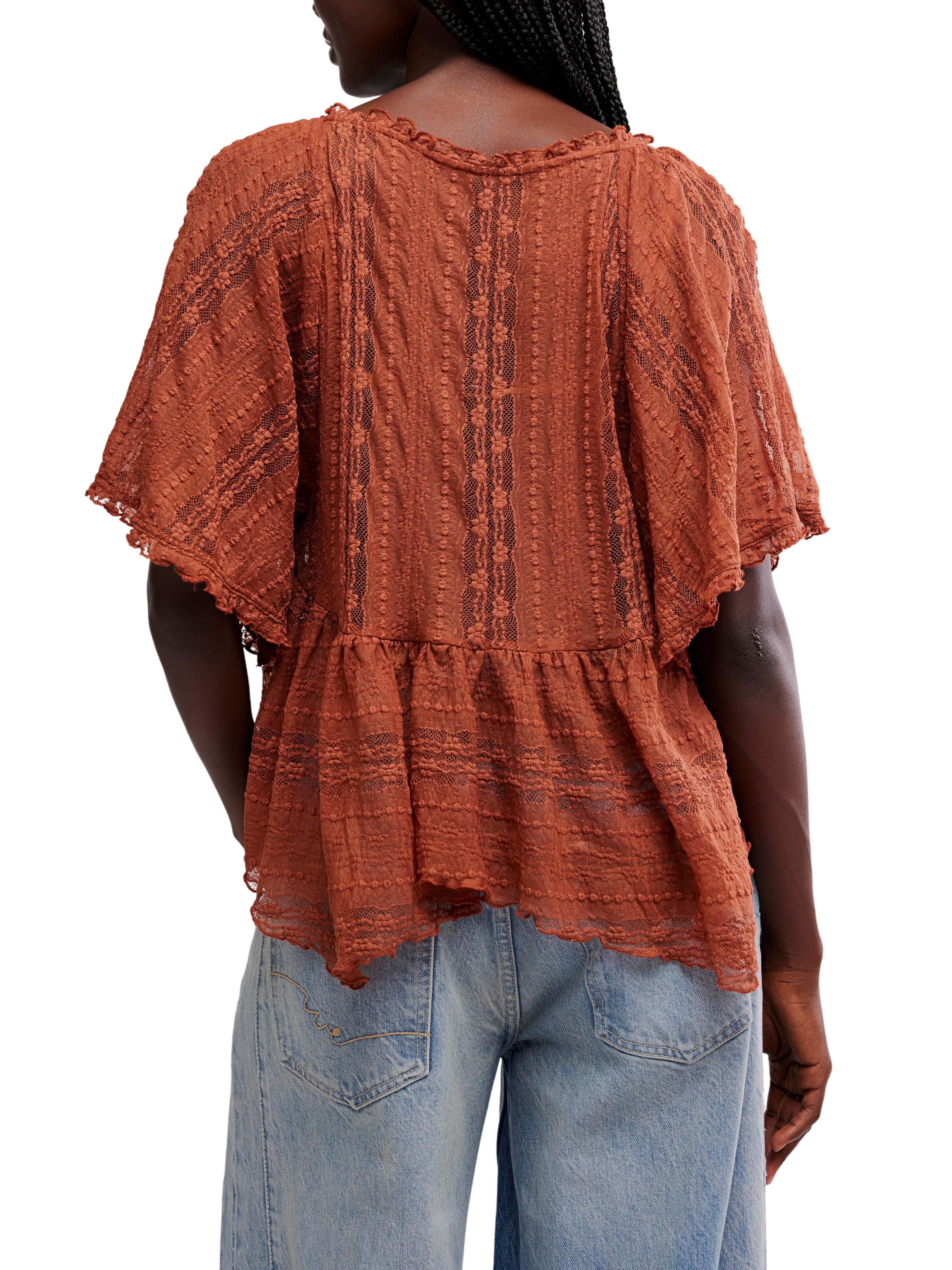 Rust-colored textured short-sleeve blouse with lace details paired with light blue denim jeans viewed from the back.