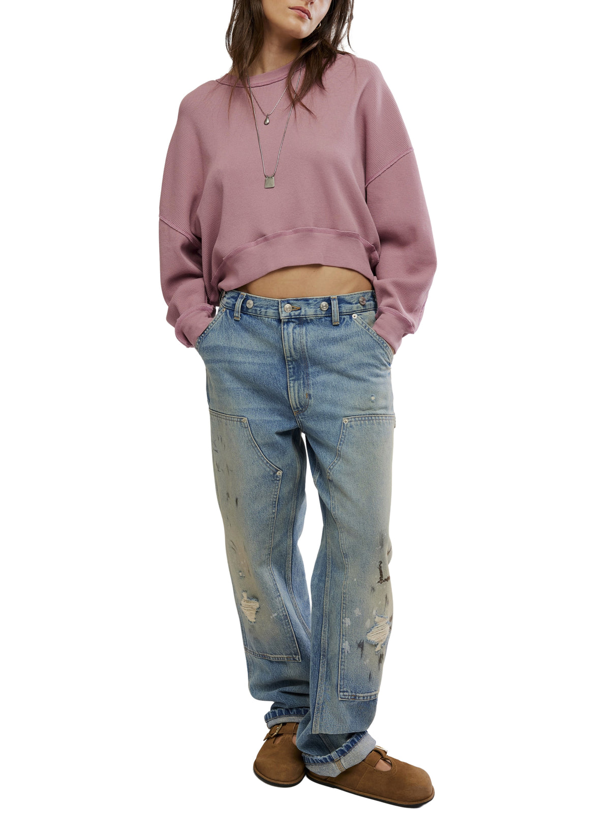 Cropped mauve sweatshirt paired with relaxed distressed blue denim jeans and brown shoes
