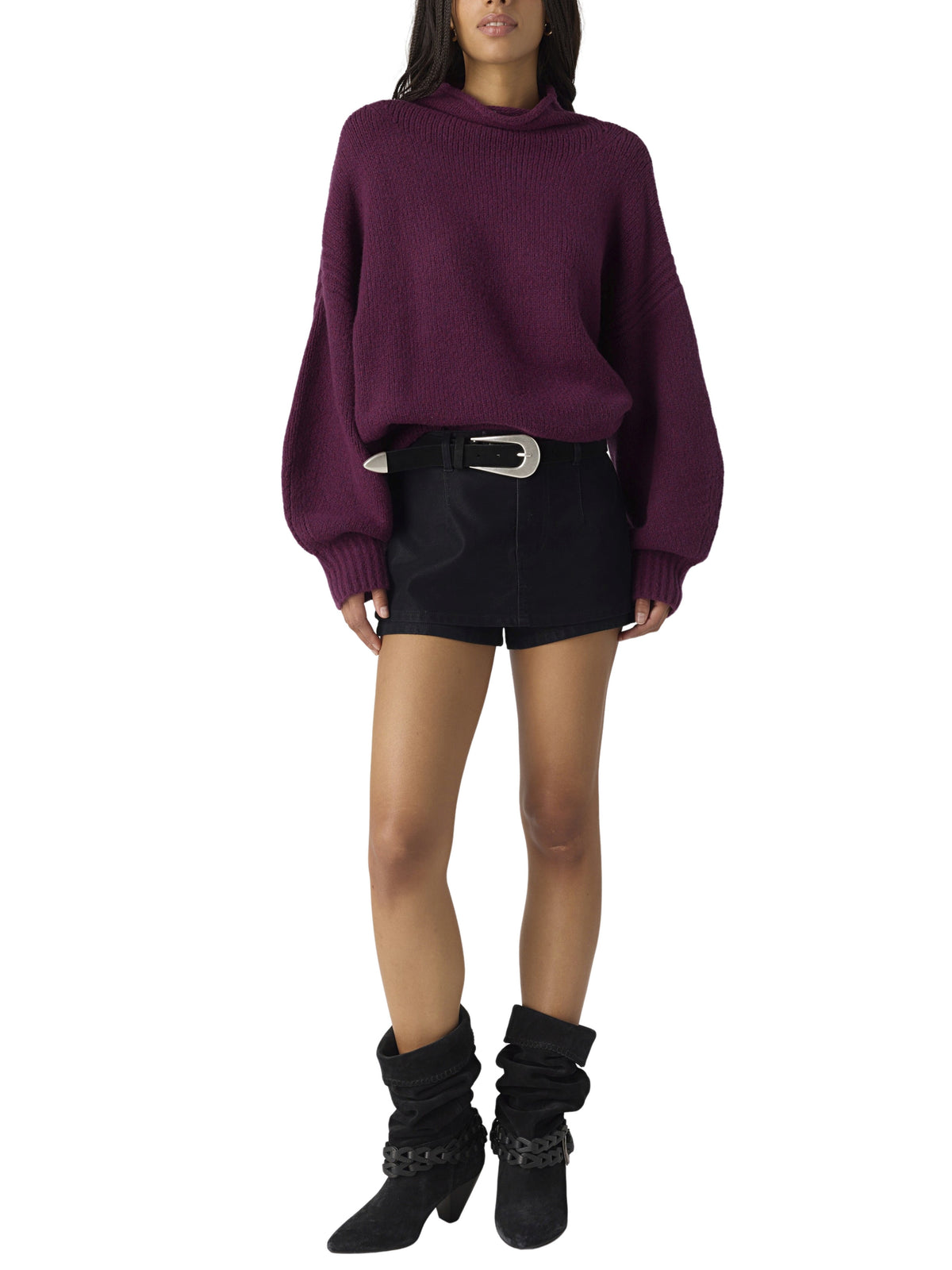 Burgundy oversized turtleneck sweater with black shorts, belt, and slouchy ankle boots