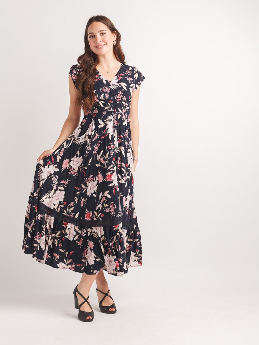 Navy blue floral maxi dress with short sleeves and tiered skirt paired with black strappy heels