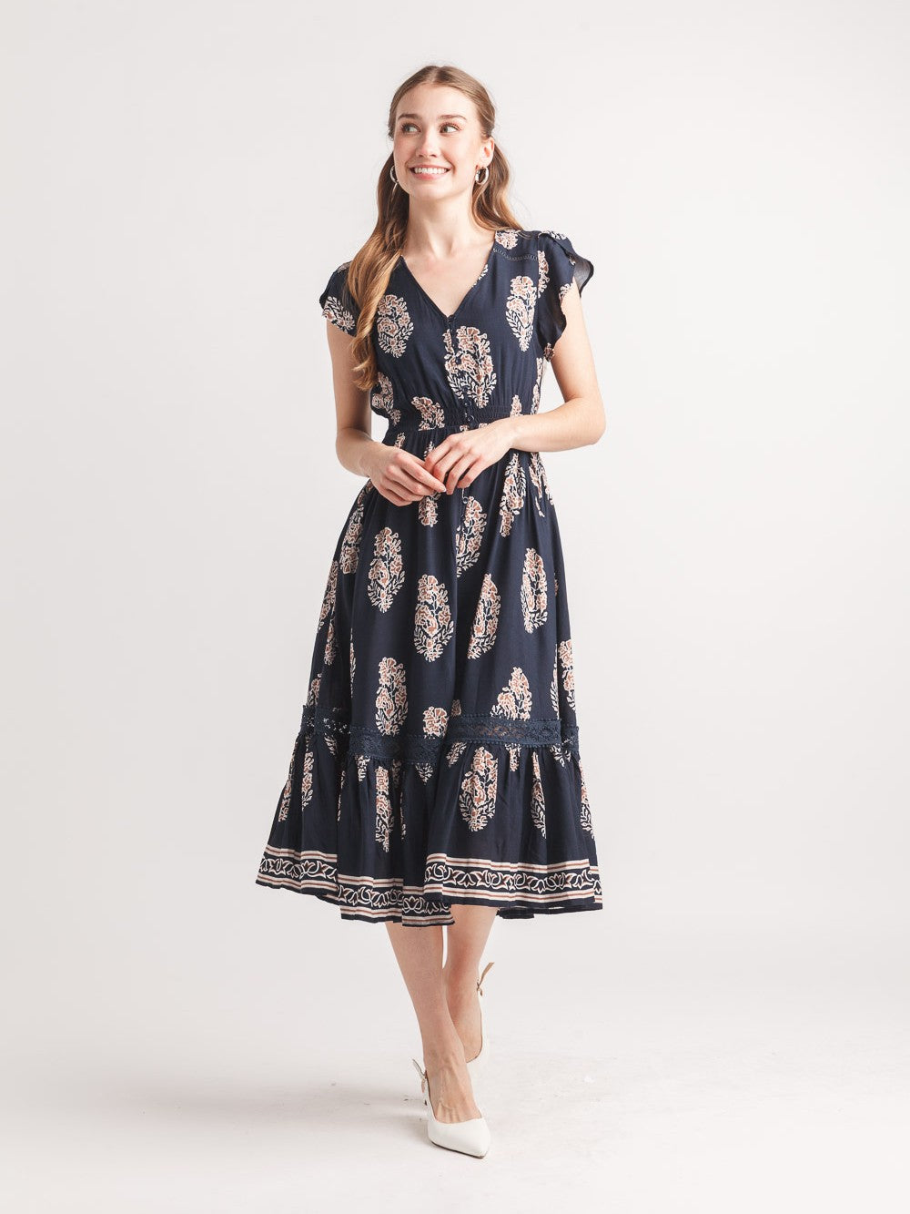 Papillon Maxed Out Printed Button Front Midi Dress in navy with floral print and ruffled hem, styled with white heels.