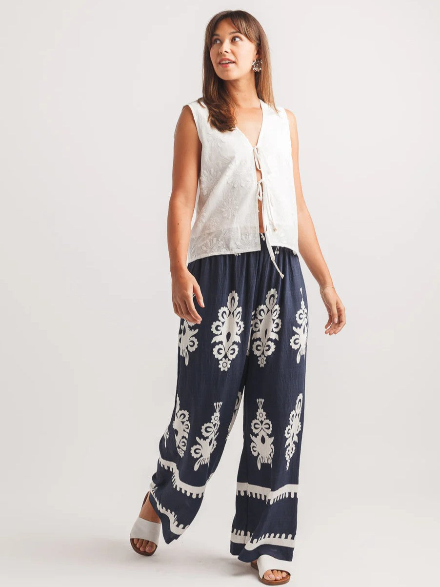 Papillon Vacation Border Hem Pull-On Wide Leg Pants in navy with white pattern, styled with white sleeveless top and sandals