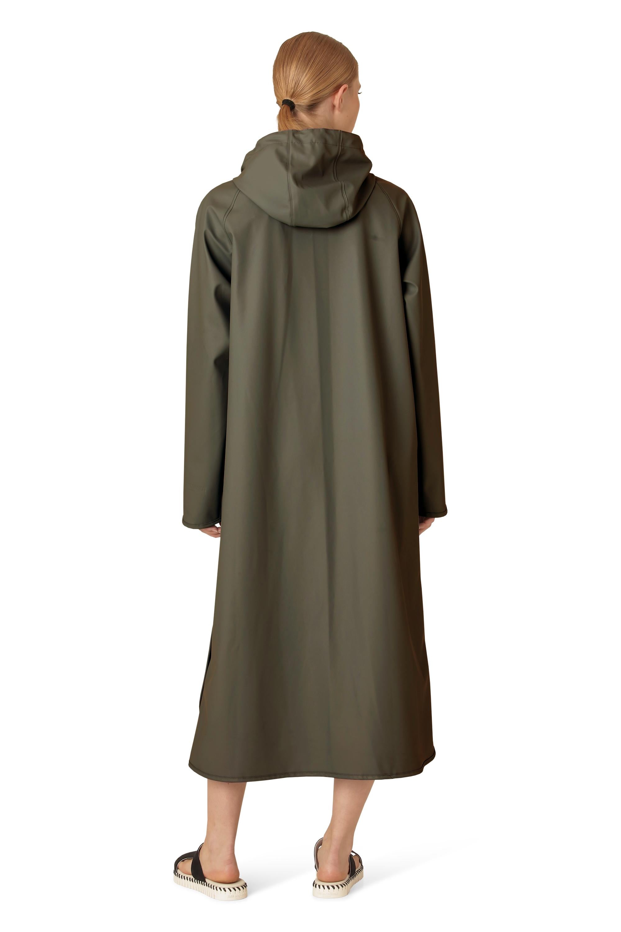 Back view of Ilse Jacobsen Waterproof Snap Hood Rain Jacket in olive, worn over casual footwear outdoors