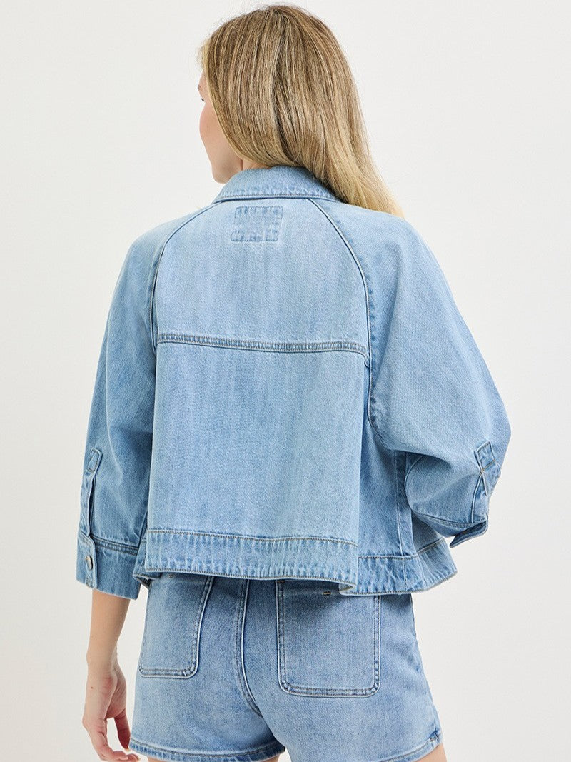 Light blue denim jacket with wide sleeves paired with matching high-waisted denim shorts, shown from the back.