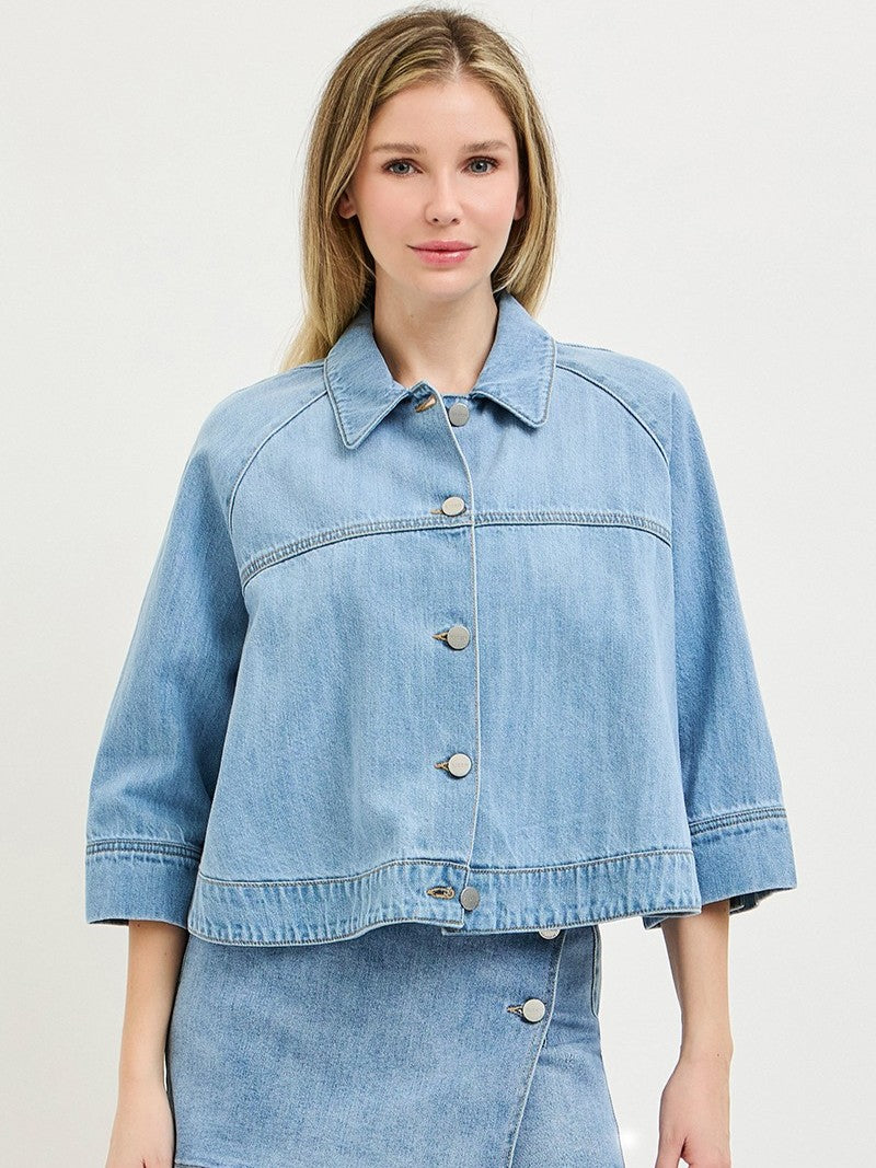 Light blue denim jacket with large buttons and wide sleeves paired with matching denim skirt.
