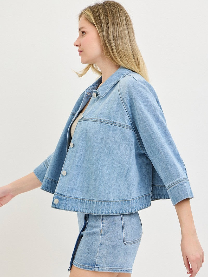 Light blue cropped denim jacket with button closure paired with matching high-waisted denim skirt.