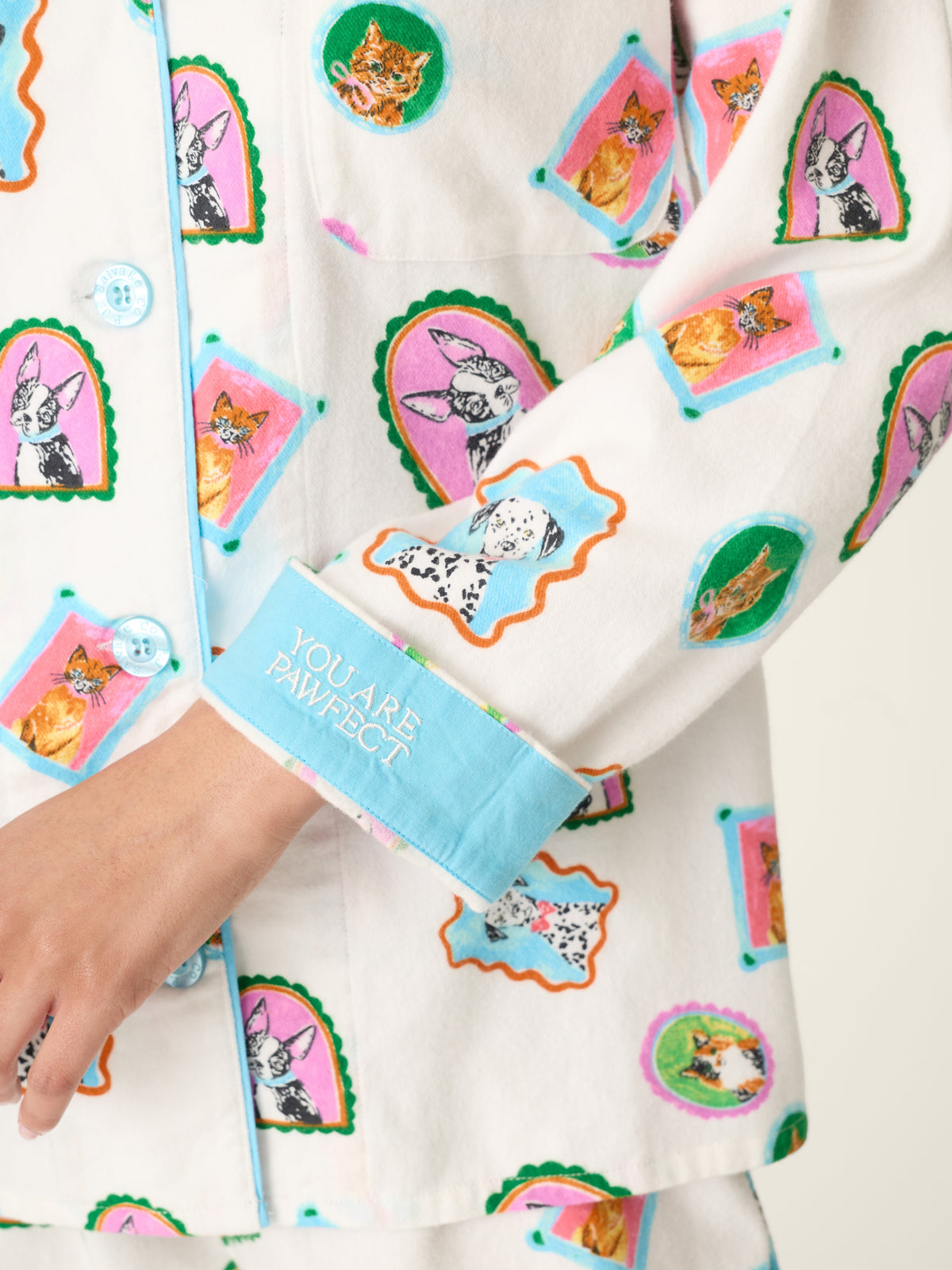 Cream patterned top with colorful cat and floral illustrations and a blue cuff reading You Are Paw Some