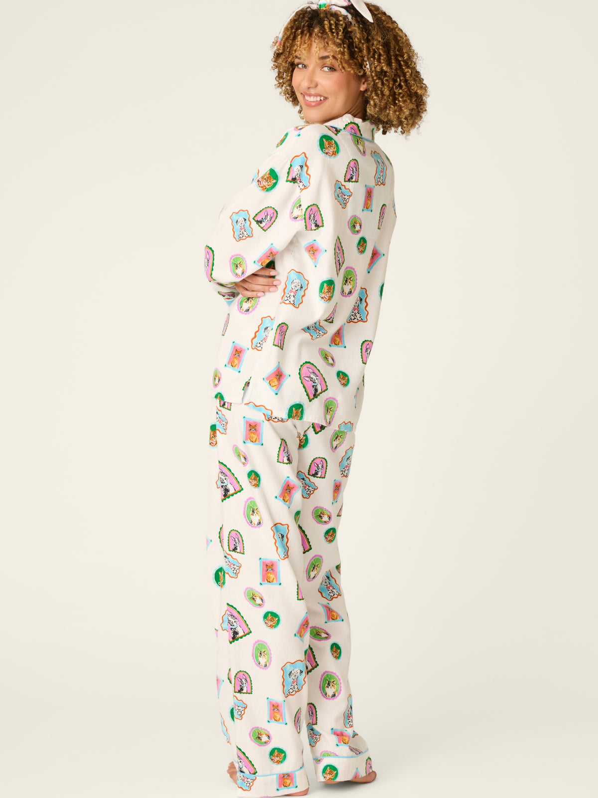 Curly-haired model in a colorful patterned pajama set with matching long-sleeve top and pants