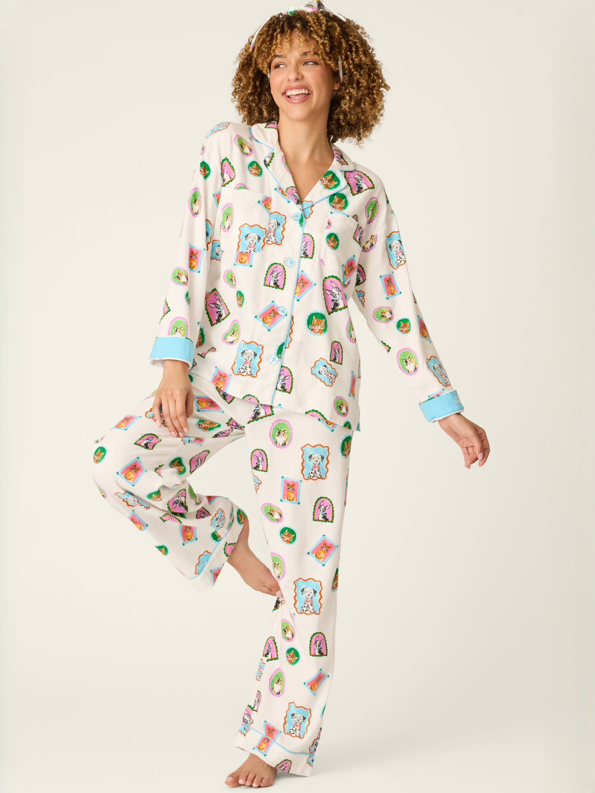 Curly-haired woman in colorful patterned pajama shirt and pants with light blue cuffs