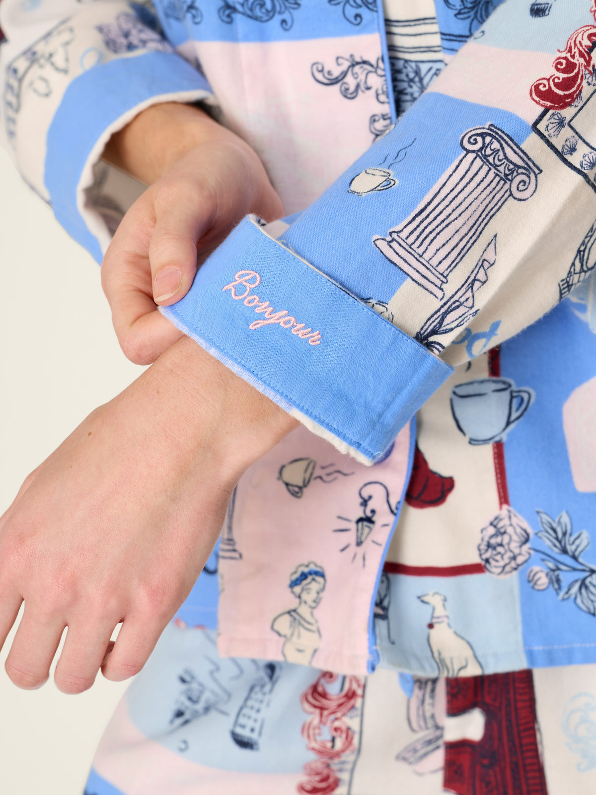 Blue and pink patterned garment sleeve with a decorative embroidered cuff detail