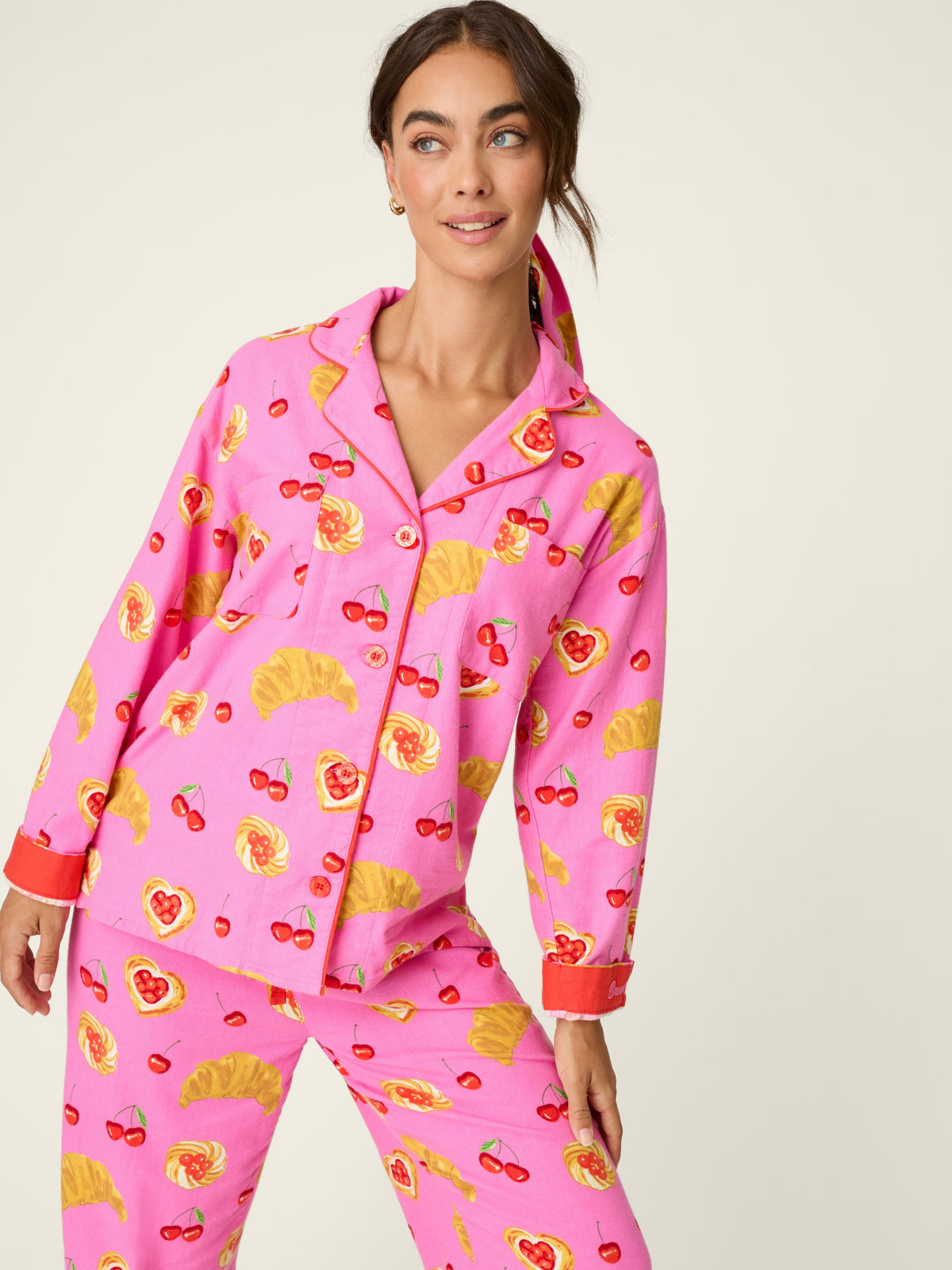 Pink patterned pajama top and matching pants with croissant, cherry, and heart prints