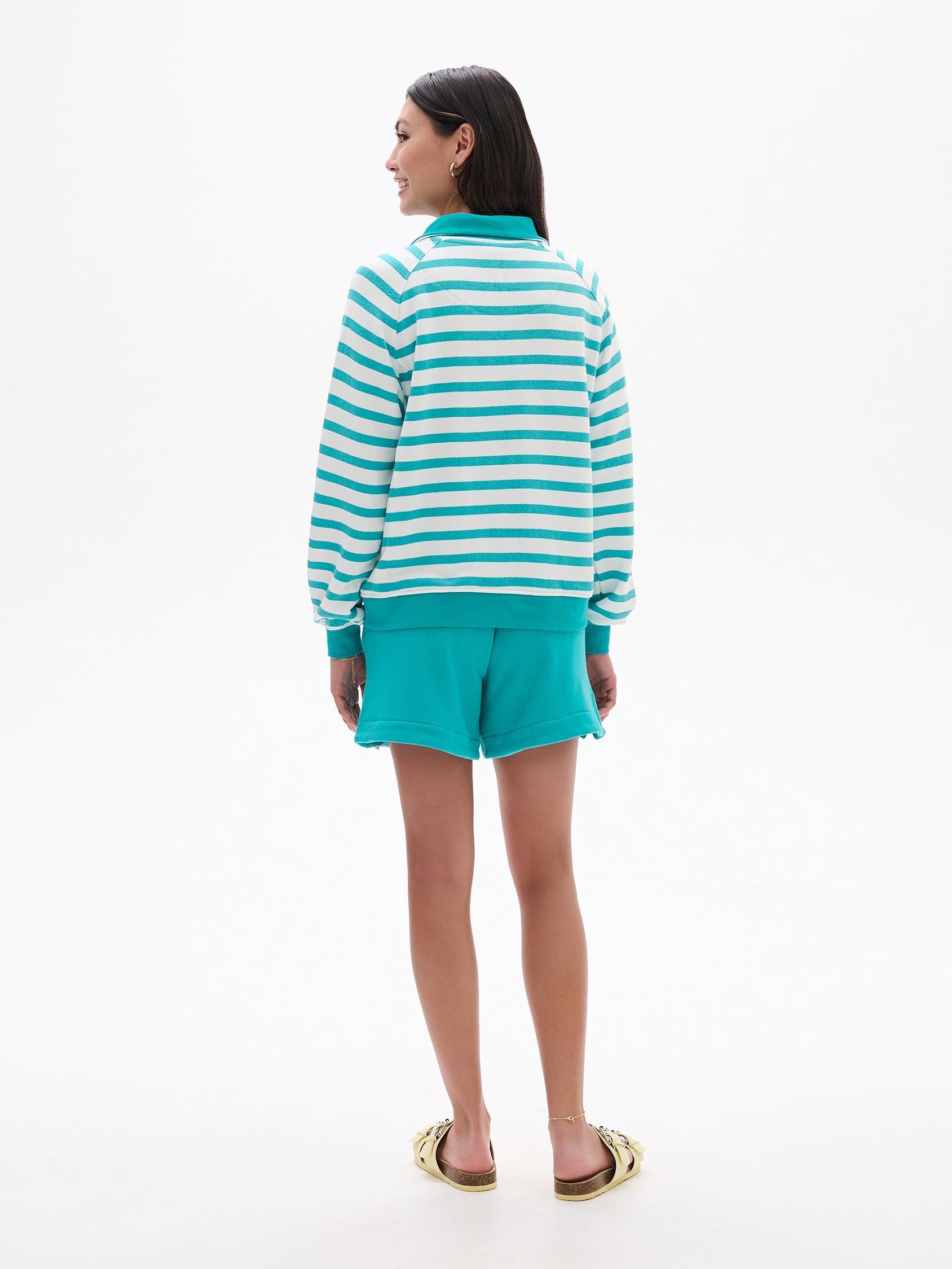 Hatley Mock Neck ¼ Zip Pullover in teal and white stripes by Hatley, styled with teal shorts and sandals.