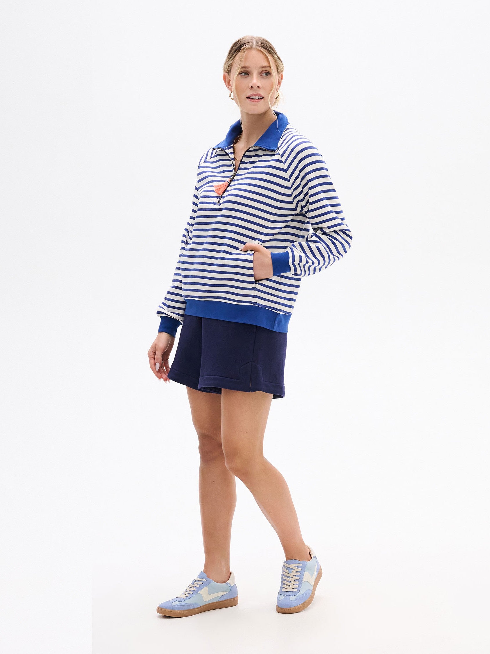 Hatley Mock Neck ¼ Zip in blue and white stripes paired with navy shorts and light blue sneakers by Hatley.