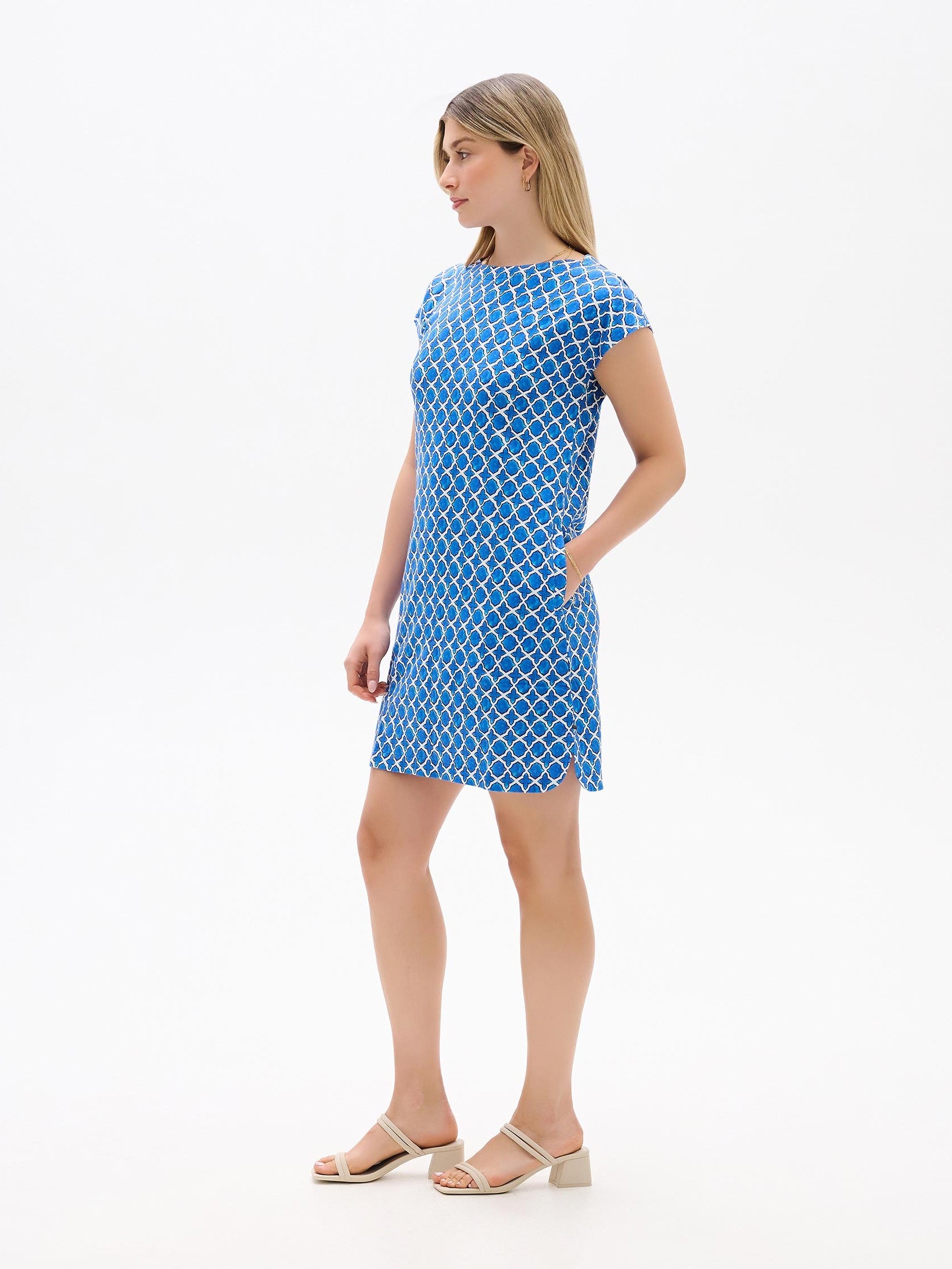 Blue patterned Hatley Capri French Dress by Hatley with short sleeves and side pockets paired with beige sandals