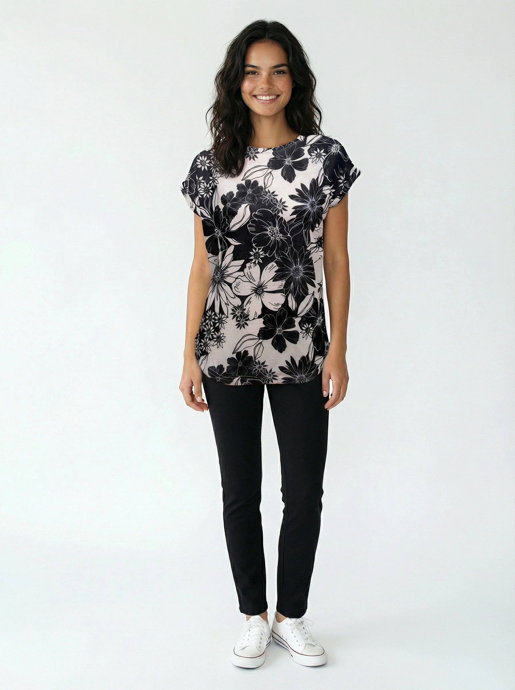 Casual outfit featuring a black and white floral patterned short-sleeve top paired with black slim pants and white sneakers.