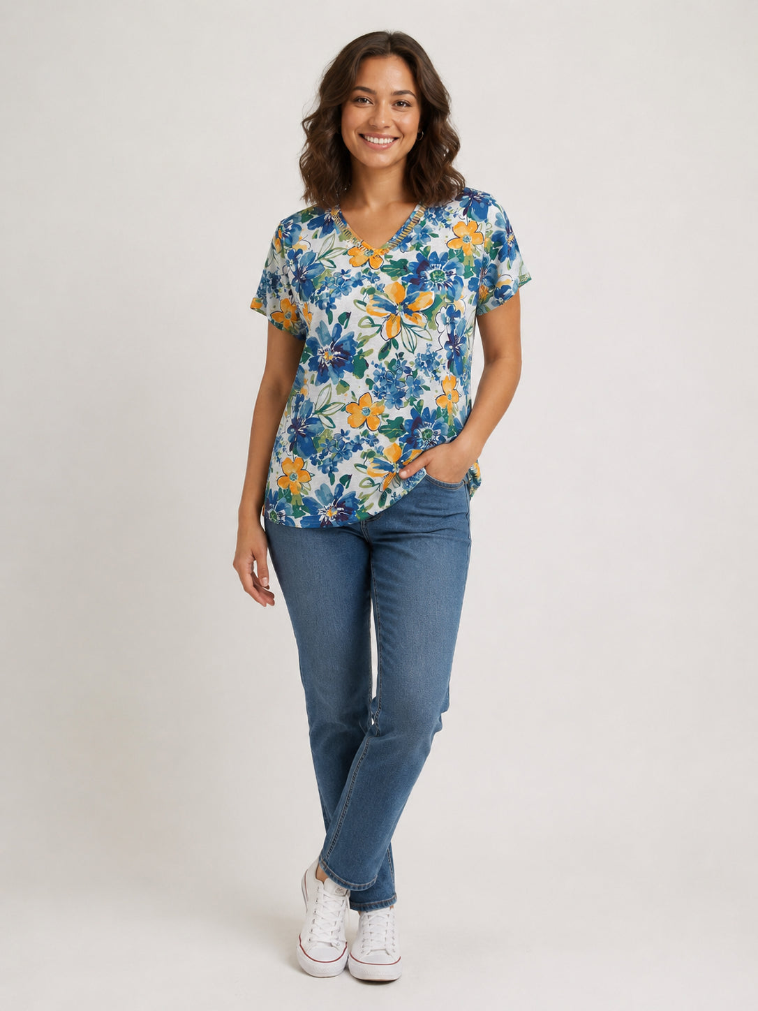 Creation Short Sleeve V-Neck Printed Top by Creations with blue and orange floral print paired with casual denim jeans and white sneakers.
