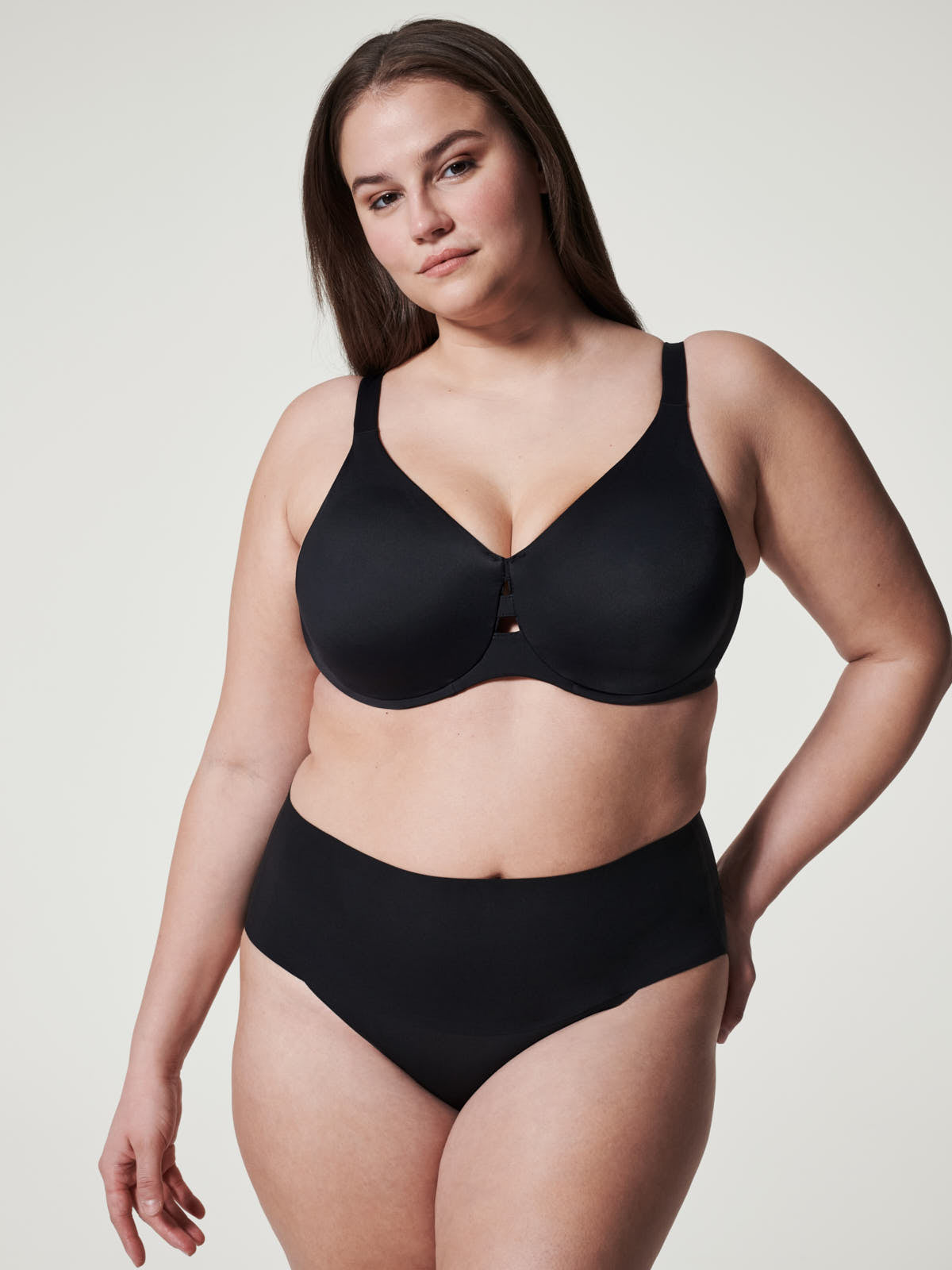 Black seamless lingerie featuring the SPANX Undie-Tectable® Brief by Spanx on a confident model.