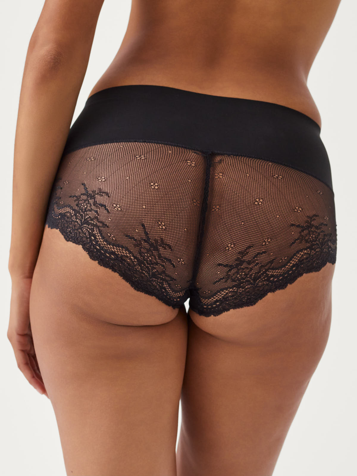 Back view of black SPANX Undie-Tectable® Lace Hipster with lace detailing by Spanx on model.