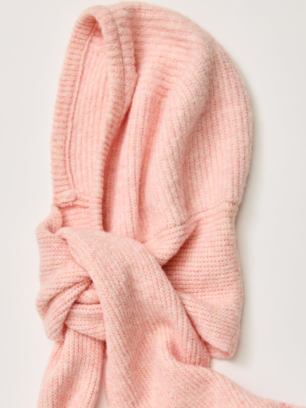 Pink knitted scarf draped against a light background