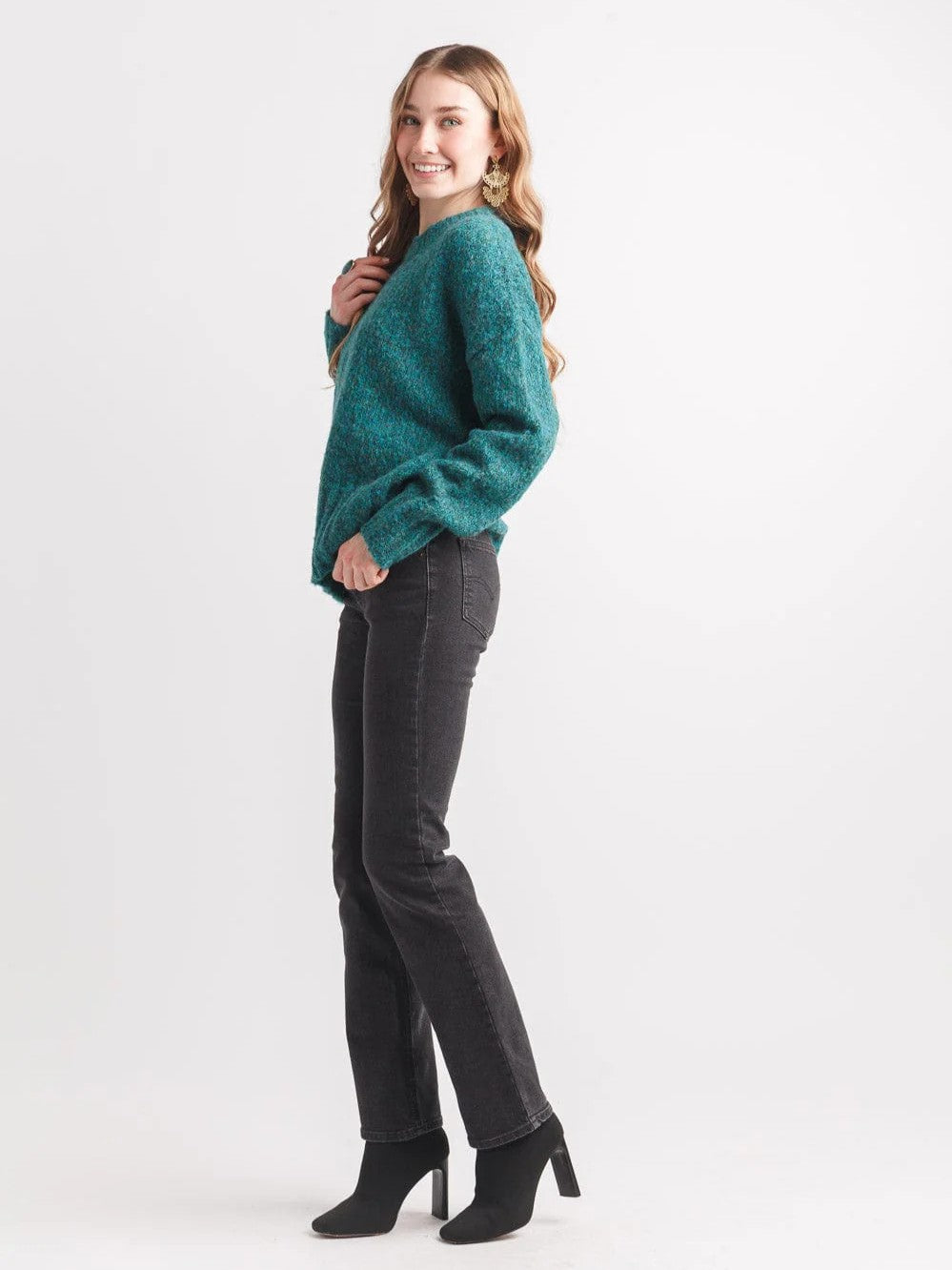 Papillon Denim Teal Pepper Crew Neck Sweater in teal knit paired with black denim jeans and black heeled boots.