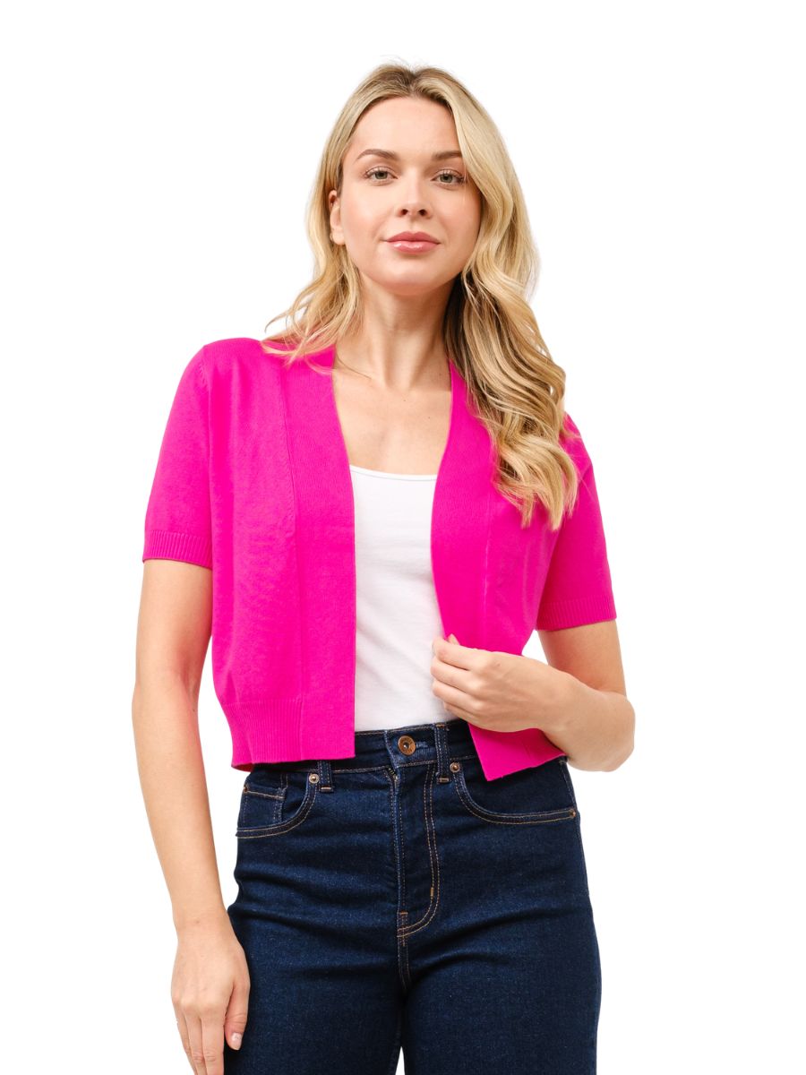 Bright fuchsia short sleeve open bolero cardigan styled with white top and dark jeans by Cielo 1985 Inc.