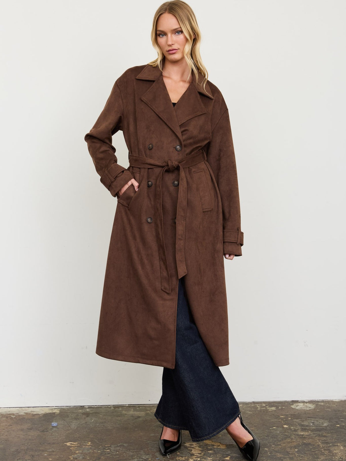 Brown belted suede look trench coat with dark flared denim trousers and black heels
