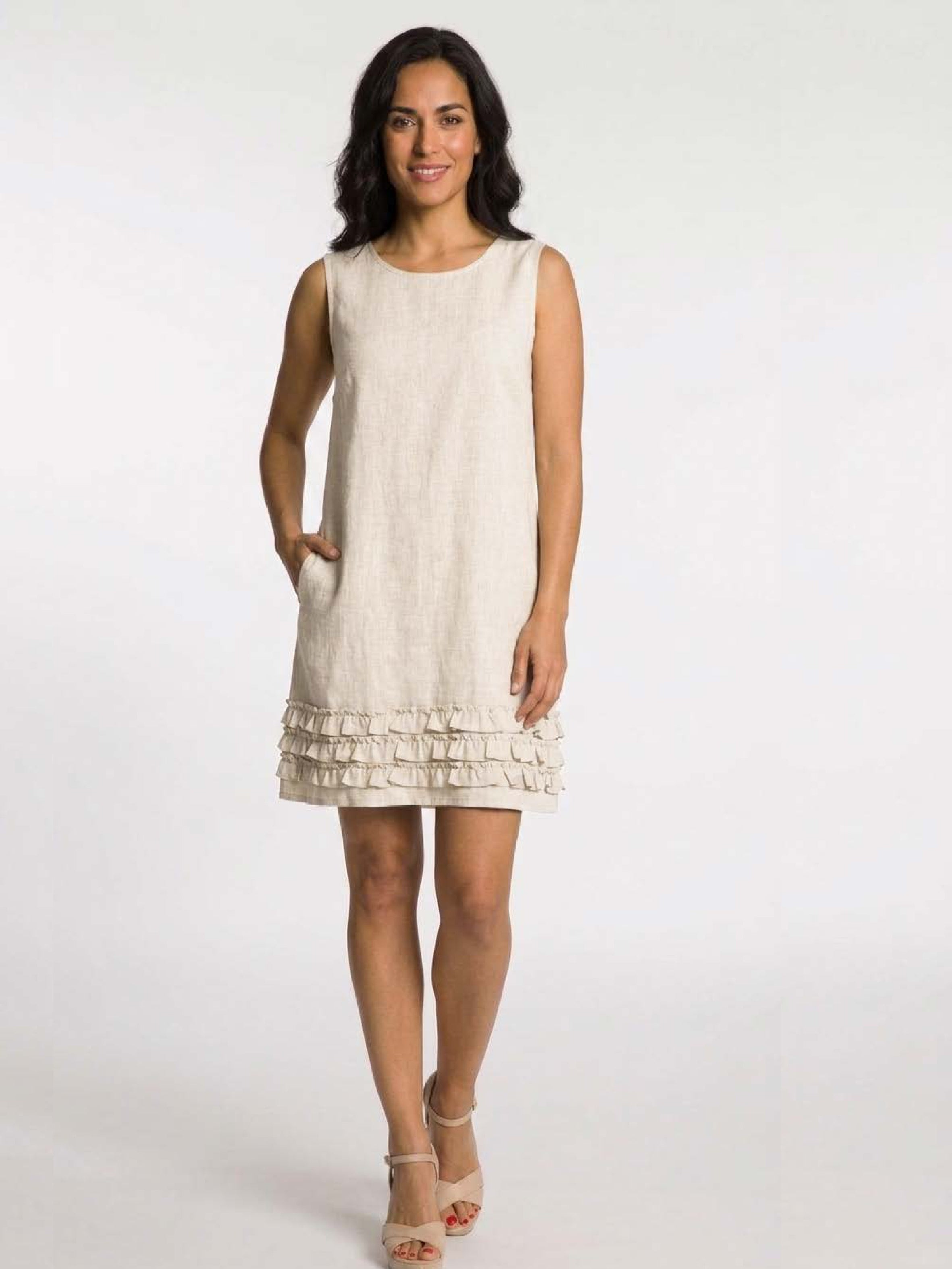 Light natural linen blend sleeveless dress with ruffle hem by DKR & Co. Apparel, styled with neutral heels.