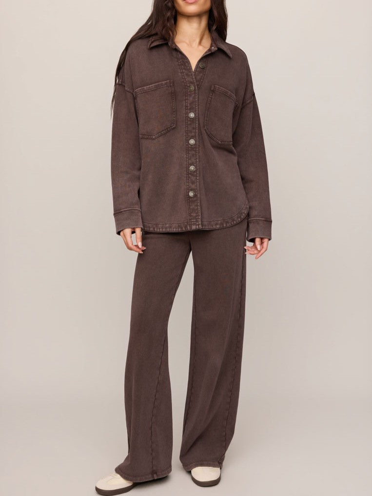 Brown oversized button-up shirt with two chest pockets paired with wide-leg matching pants and casual shoes.