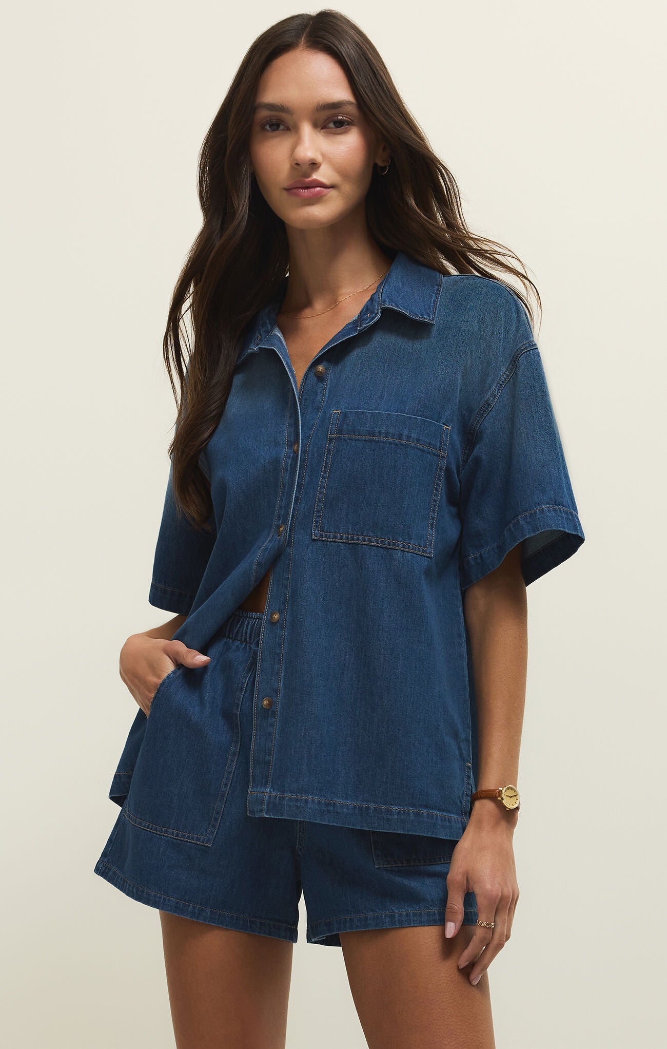 Z Supply Everyday Short Sleeve Denim Shirt in dark blue with front pocket, styled with matching shorts by Z Supply.