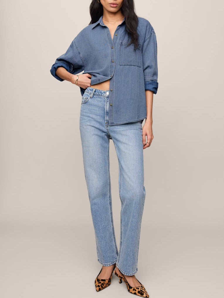 Blue denim button-up shirt paired with light wash straight-leg jeans and leopard print pointed shoes.