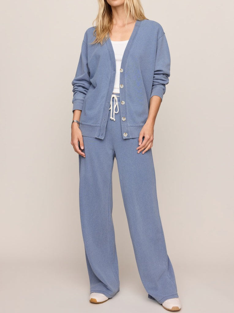 Light blue button-up cardigan paired with matching wide-leg drawstring pants and white sneakers.